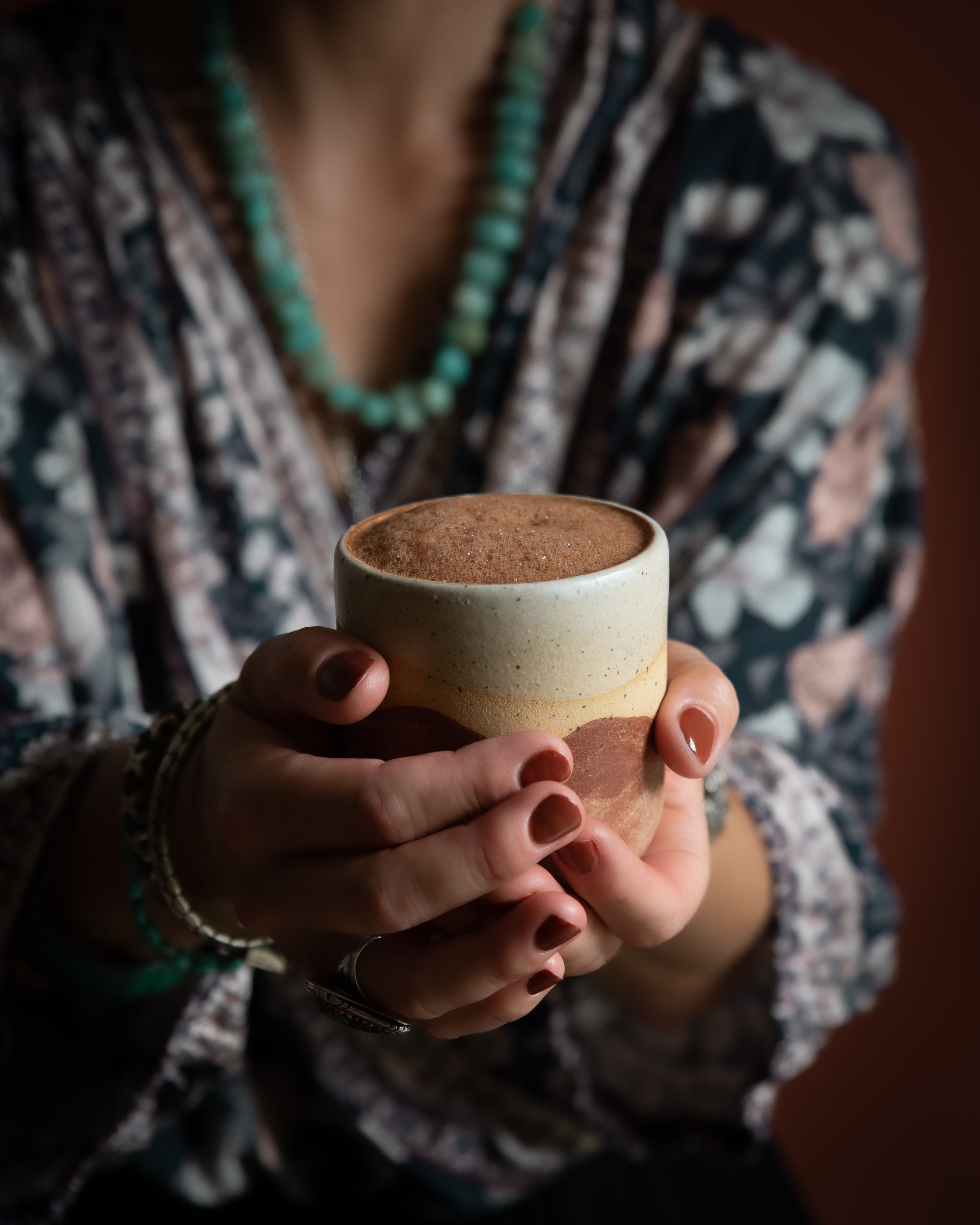 Hands around Mamamuti Cacao in mug